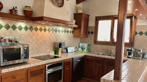 A kitchen with wooden cabinets, a microwave, a dishwasher, and a sink. - VILLA VICTORIA (SON BLANC) (Son Blanc)
