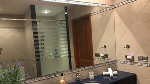 A bathroom with a dark blue sink, white tiles, a large mirror, and a wooden door. - VILLA VICTORIA (SON BLANC) (Son Blanc)