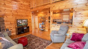 Een vakantiehuisje van hout met een woonkamer, keuken en balkon.