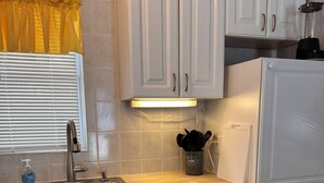 A kitchen with white cabinets, a stainless steel sink, and a wooden countertop. - STEPS TO GULF BEACH! (Holmes Beach)