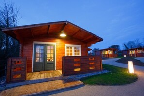 Guests can enter through the cabin's front entrance, surrounded by a beautifully maintained lawn and a gravel pathway.