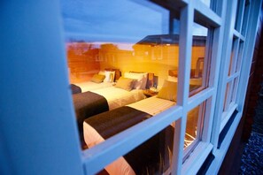 Two beds with unique headboards, a large window, and a minimalist interior design.
