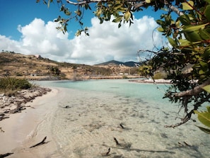 A beach with clear turquoise water, sandy shore, and distant hills. - Casa Del Tamaris,10 mn walk to Orient Bay beach, swimming pool, tropical garden (Saint Martin)