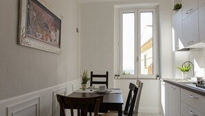 Un coin repas avec une table et des chaises, une fenêtre donnant sur un paysage agréable et un espace cuisine avec des placards.