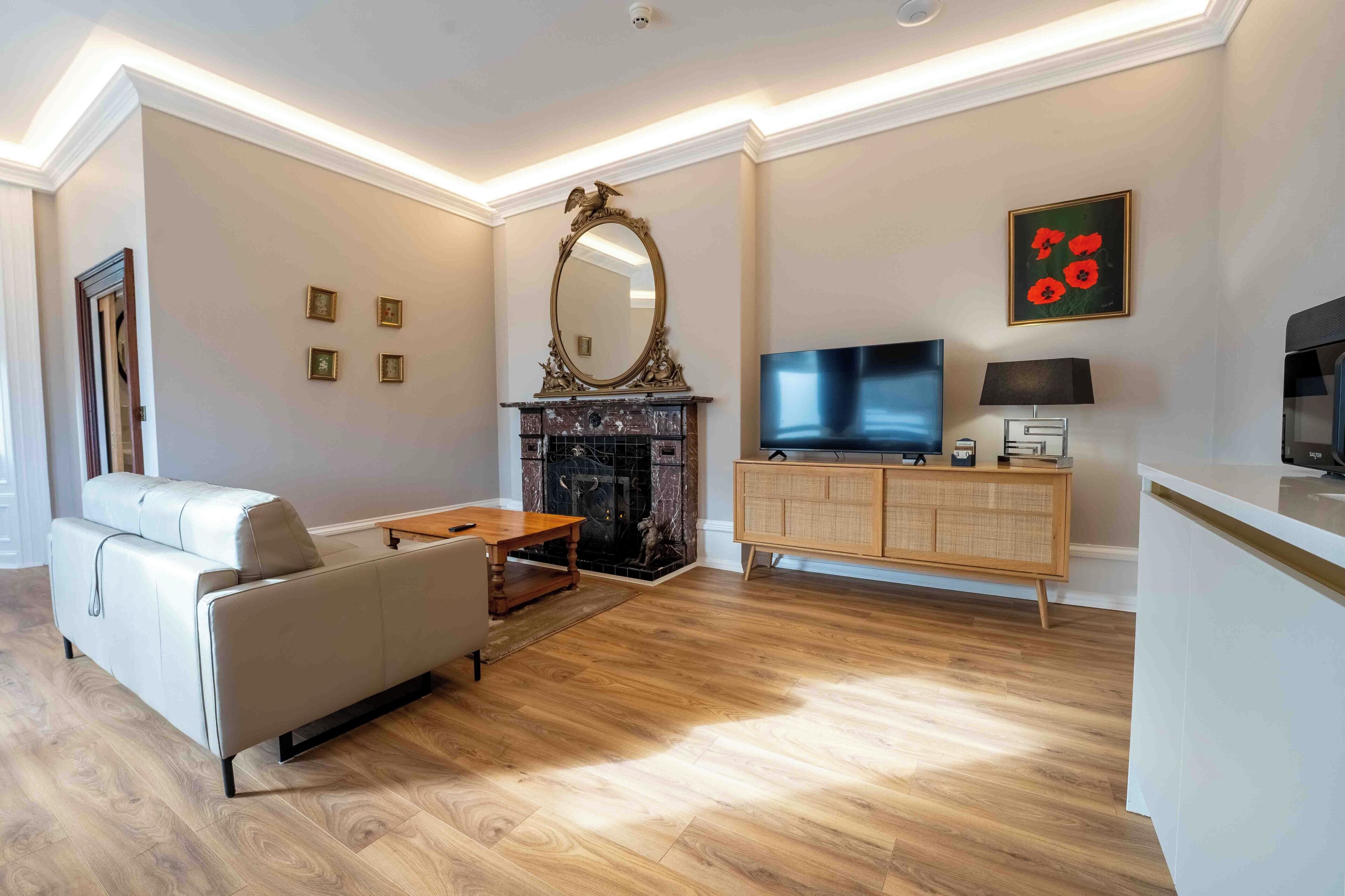 Uma sala de estar moderna com lareira, um sofá, uma televisão e um armário.