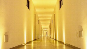 A long, narrow hotel corridor with a central light source and a door at the end. - Beautiful Menesse the city, Delux Apartment (Playa del Carmen)