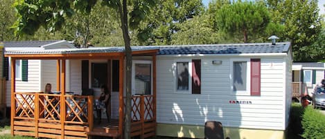 A mobile home with a porch and a small deck, labeled 'ADRIA'.