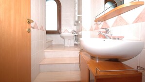 Een badkamer met een groot wastafel, een spiegel en een douche.