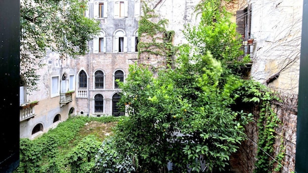 Un edificio antiguo con ventanas de arco y un patio.