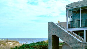 Un immeuble de deux étages doté d’un balcon donnant sur la plage.
