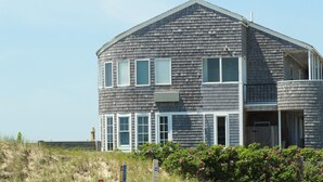 A two-story house with a gabled roof, multiple windows, and a front porch.