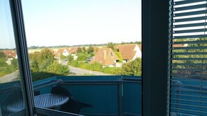 Ein Balkon mit Blick auf Häuser und Grünflächen.