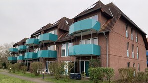 Eine Reihe von Backsteinwohngebäuden mit mehreren Balkonen.