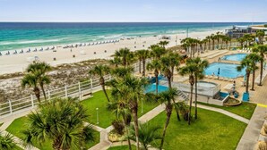 A beach resort with a pool area, palm trees, and a view of the ocean. - The Summit 531 (Panama City Beach)