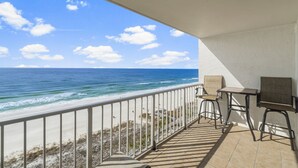 A balcony with a view of the ocean, a table, and two chairs. - The Summit 1128 (Panama City Beach)
