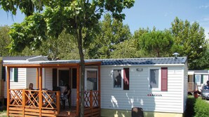 Ett husvagn med en veranda och en liten terrass, märkt med texten ”ADRIA”.