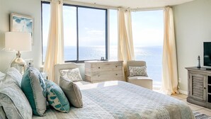 A bedroom with a large bed, a dresser, a chair, and a TV. - The Summit 621 (Panama City Beach)