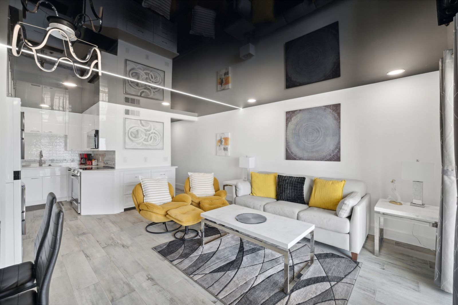 A modern living space with a kitchen, dining area, and seating area.
