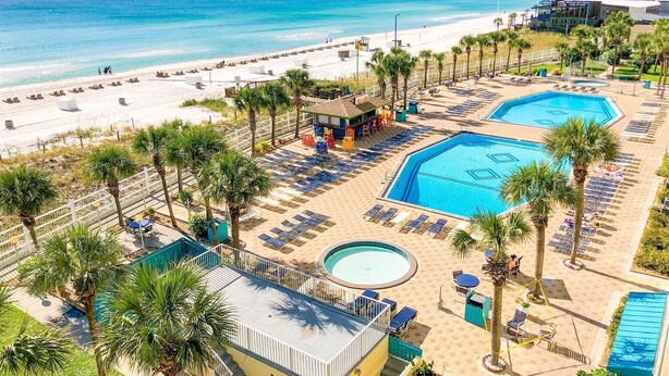 A resort with a beach, two swimming pools, and a bar area. - The Summit 702 (Panama City Beach)