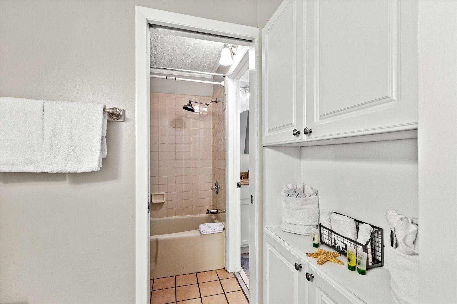 A bathroom with a bathtub, a shower, and a towel rack.