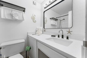 A modern bathroom with a white sink, mirror, and towel rack. - Top Of The Gulf 815 (Panama City Beach)
