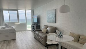A modern living room with a sofa, a coffee table, and a TV. - Top Of The Gulf 815 (Panama City Beach)