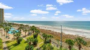 Hotel aan het strand met een zwembad, palmbomen en uitzicht op de oceaan.