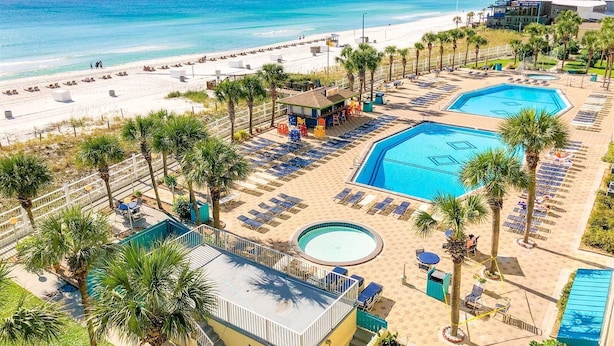 A resort with a beach, two swimming pools, and a bar area. - The Summit 104 (Panama City Beach)