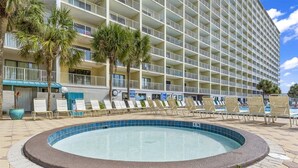 A hotel with a large pool area, multiple balconies, and lounge chairs. - The Summit 104 (Panama City Beach)
