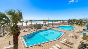 A resort with two swimming pools, palm trees, and a beach view. - The Summit 1130 (Panama City Beach)