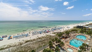 Ein Strandresort mit mehreren Swimmingpools, Strandsonnenschirmen und freiem Blick auf den Ozean.