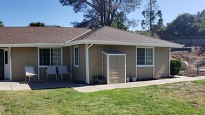 A two-story house with a covered porch, a fenced yard, and a well-maintained lawn.