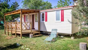 A small, single-story mobile home with a wooden deck and a covered porch. - Victoria Mobilehome Camping Imperial (Vodice)