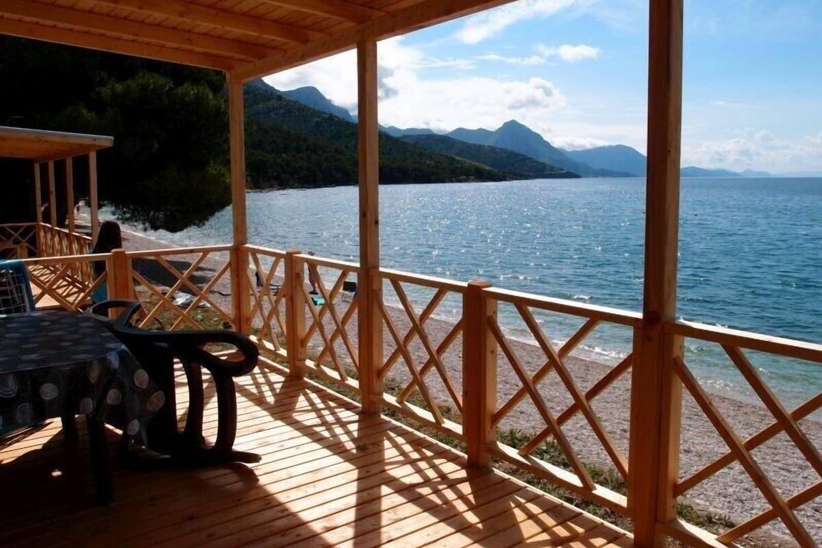 A wooden deck with a view of a lake and mountains.