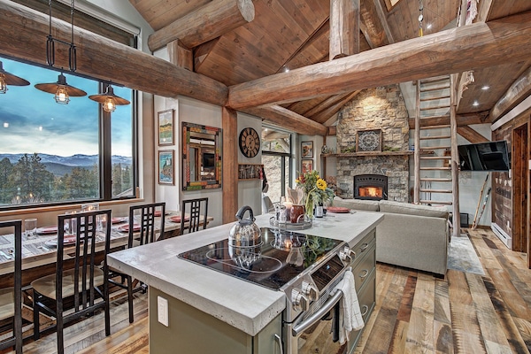 Majestic main room Majestic main room A modern kitchen with amazing views shares space beneath impressive support logs with the coziest living room ever.