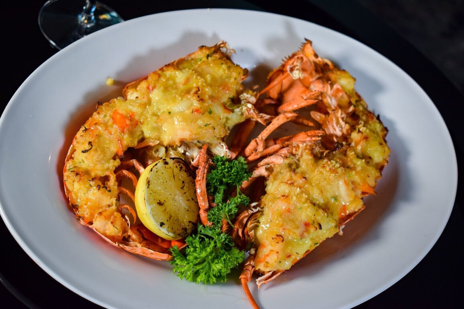 A plate of cooked crabs with lemon slices and parsley garnish.