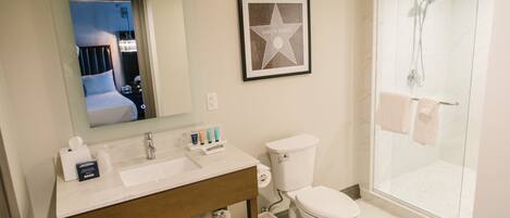 A bathroom with a sink, toilet, and glass-enclosed shower.