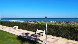A coastal walkway with benches and a lamppost, leading to the ocean. - Anacasa Bahia de Denia Les Marines AP2102 (Denia)