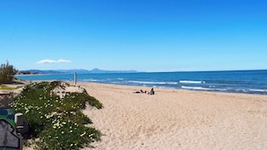 A beach with a clear sky, sandy shore, and a few people relaxing. - Anacasa Bahia de Denia Les Marines AP2102 (Denia)