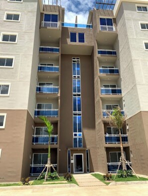 A multi-story building with a central entrance, balconies on each floor, and a clear sky. - Summer paradise, total relaxation on your vacation (Stgo)