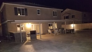 Une maison à deux étages dotée d’un patio couvert.