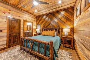 Un dormitorio tipo cabaña con cama de madera, cómoda y tocador con espejo.