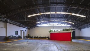 An indoor space with a high ceiling, a red counter, and potted plants. - Hotel SR92 Only Adults (Mexico City)