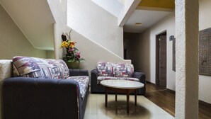 A spacious living area with two sofas and a coffee table, a staircase, and a decorative plant. - Hotel SR92 Only Adults (Mexico City)