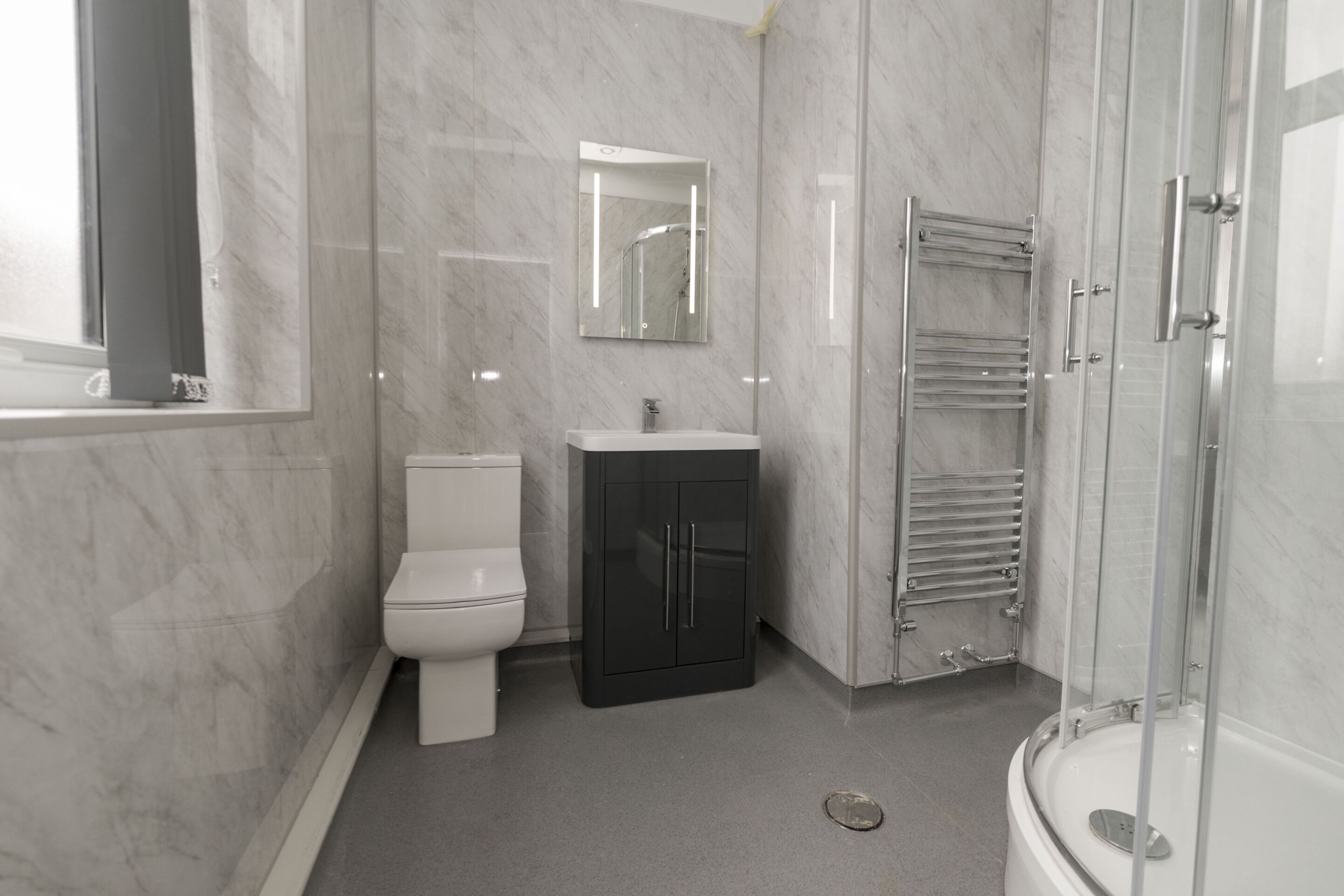 A modern bathroom with a toilet, sink, and shower.