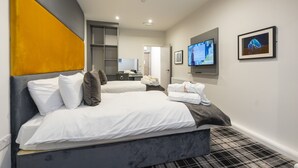 A hotel room with two beds, a TV, a mirror, and a wardrobe. - 42 Apart-hotel (Scunthorpe)