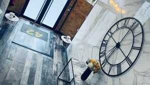 A modern lobby with a large clock, a reception desk, and a wooden-framed door. - 42 Apart-hotel (Scunthorpe)