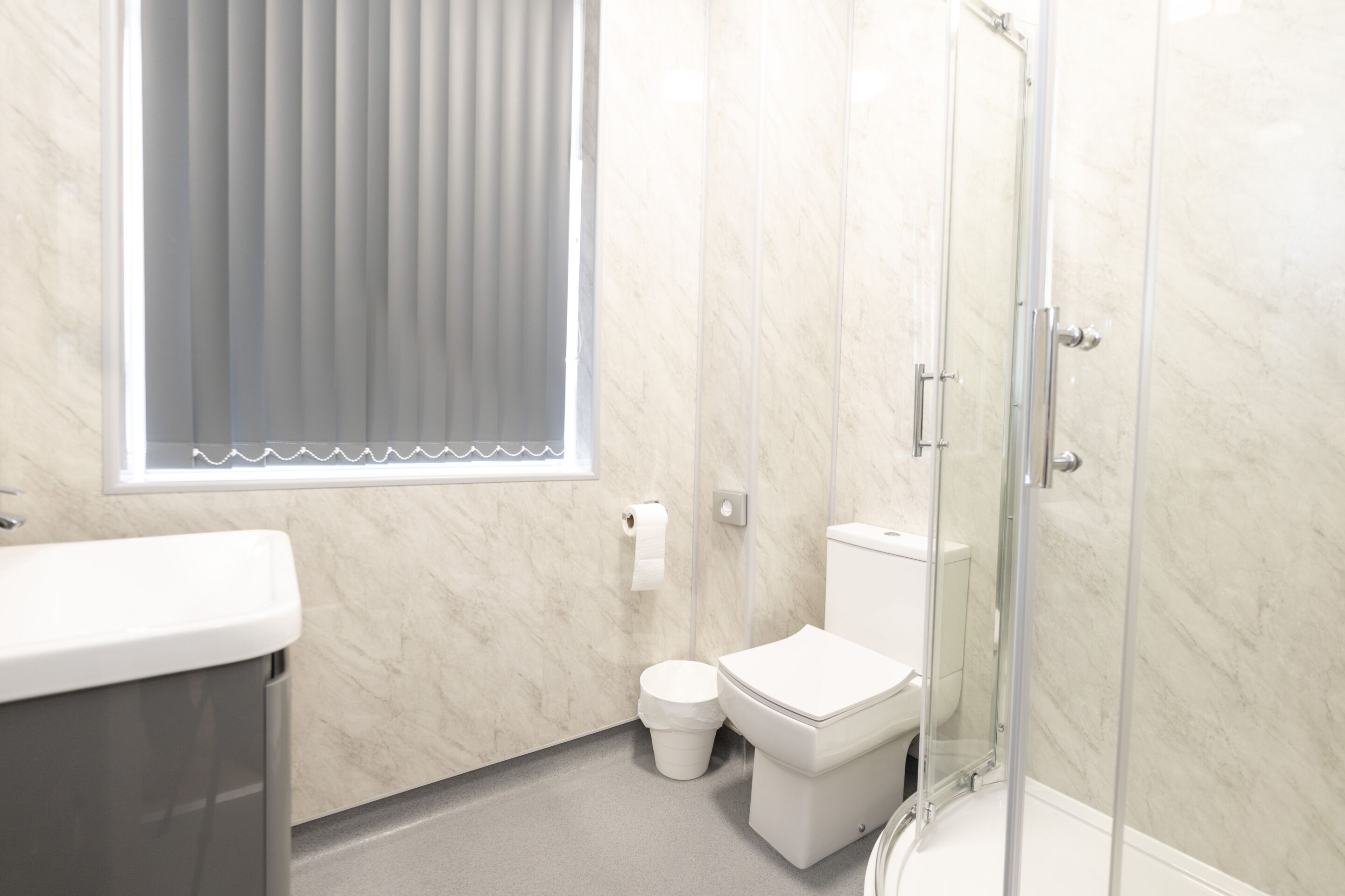A bathroom with a toilet, a sink, and a shower.