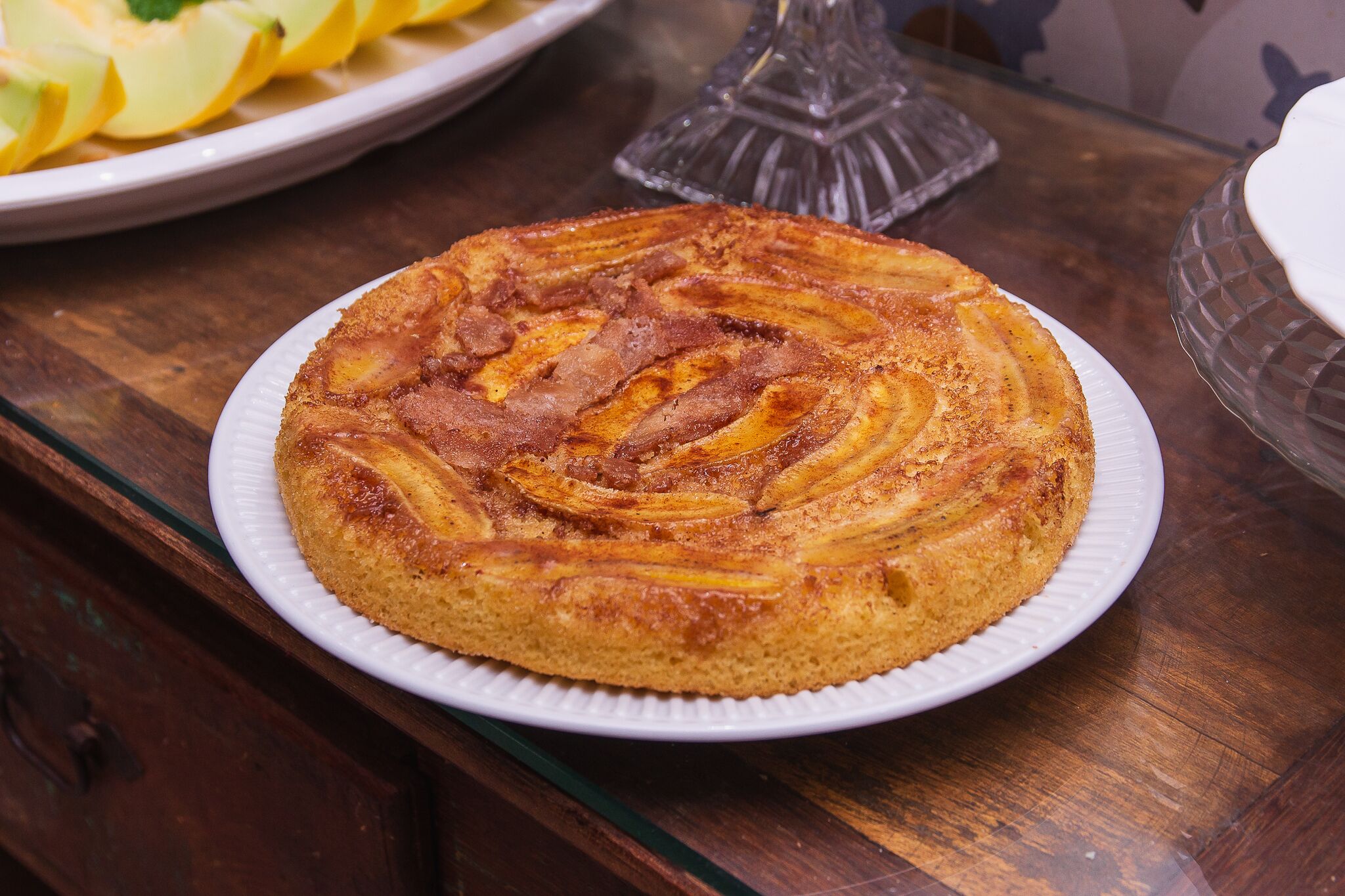 Un pastel redondo con corteza dorada sobre un plato blanco.