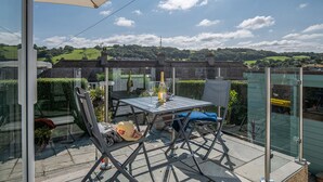 A patio with a table, chairs, and a large umbrella. - Heddfan (Conwy)